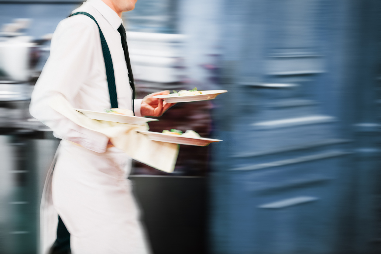 Server carrying freshly prepared food at Rooh Nashville, a Holiday Inn Nashville Airport restaurant near BNA